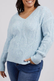 A model wearing the Tallulah Cable Knit in colour Bluemist (Blue), from the front, cropped image