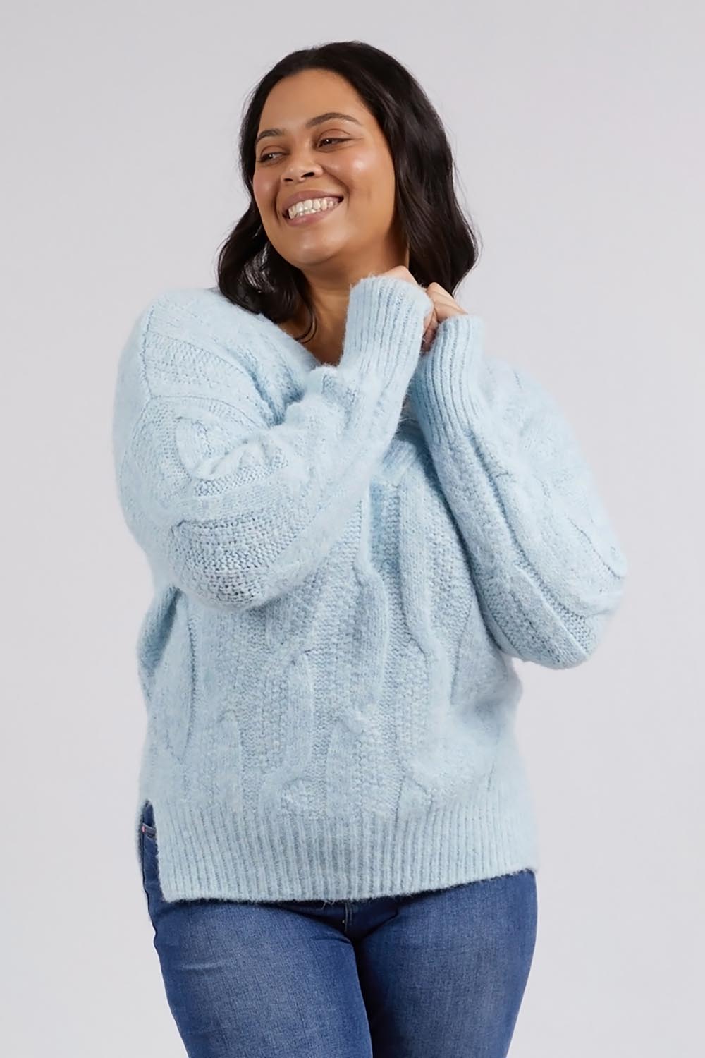 A model wearing the Tallulah Cable Knit in colour Bluemist (Blue), from the front, cropped image