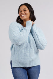 A model wearing the Tallulah Cable Knit in colour Bluemist (Blue), from the front, cropped image