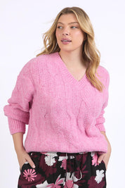 A model wearing the Tallulah Cable Knit in colour Pinkger (Pink), from the front, cropped image