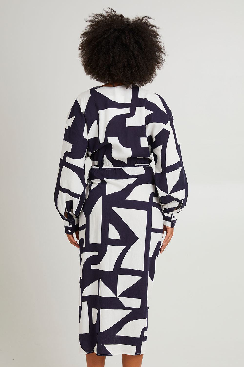 Model Olivia wearing size 10 of the Dali Abstract Dress in colour Midnight (Blue), from the back