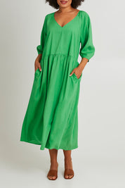 Model Olivia wearing size 10 of the Rosalie Dress in colour Greenbriar (Green), from the front, cropped image