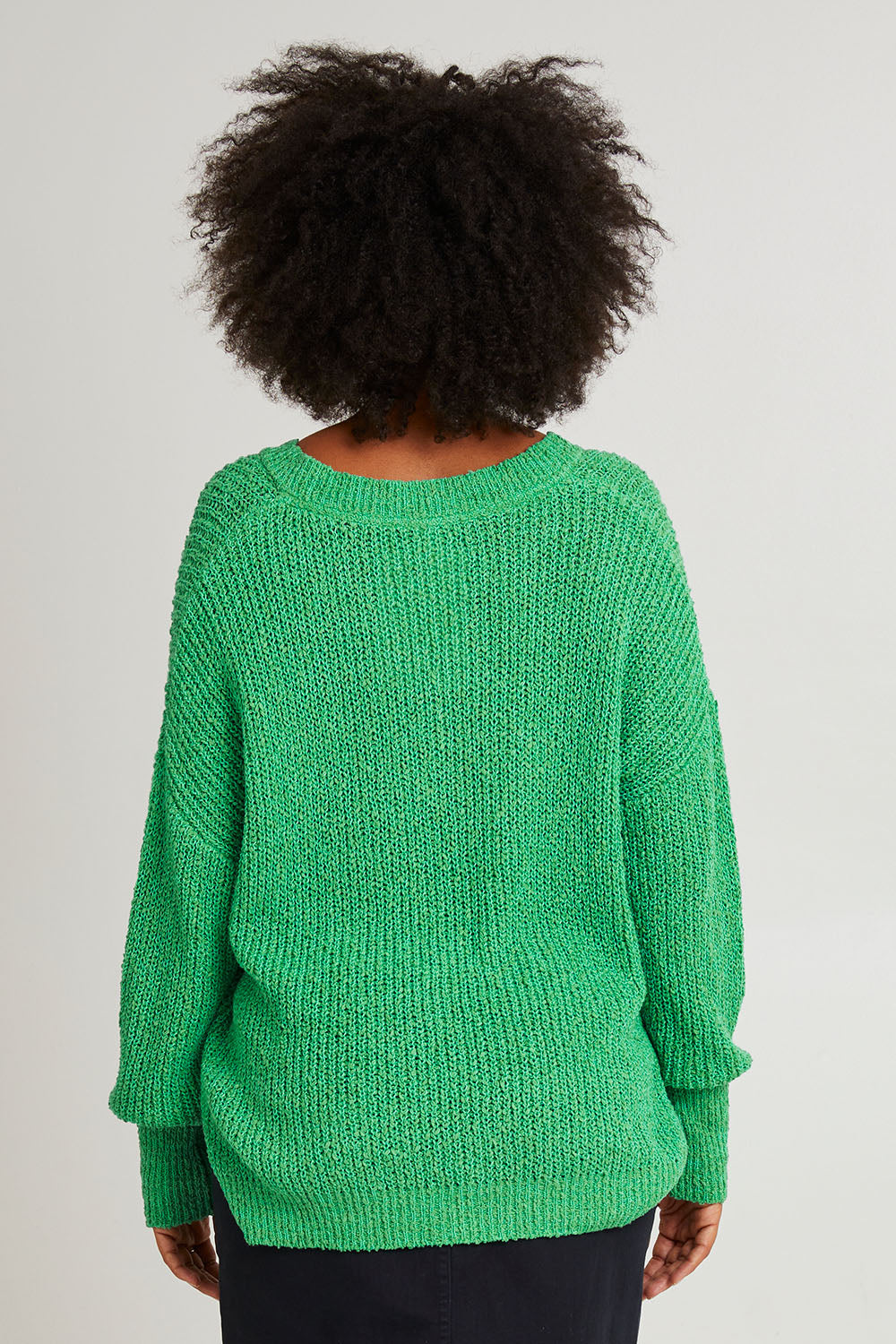 Model Olivia wearing size S of the Rachele V Neck Knit in colour Greenbriar (Green), from the back