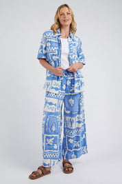 A model wearing the Holiday Sun Pant in colour Cerulean (Blue), from the front, showing the whole outfit