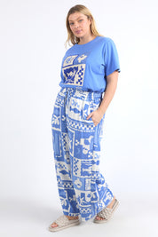 A model wearing the Holiday Sun Pant in colour Cerulean (Blue), from the front, showing the whole outfit