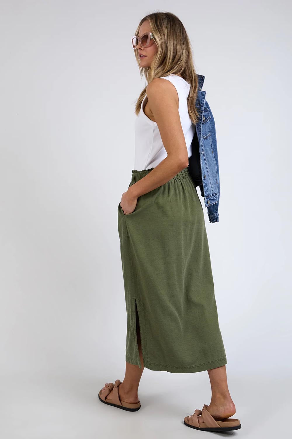 A model wearing the Mila Utility Skirt in colour Clover (Green), from the back