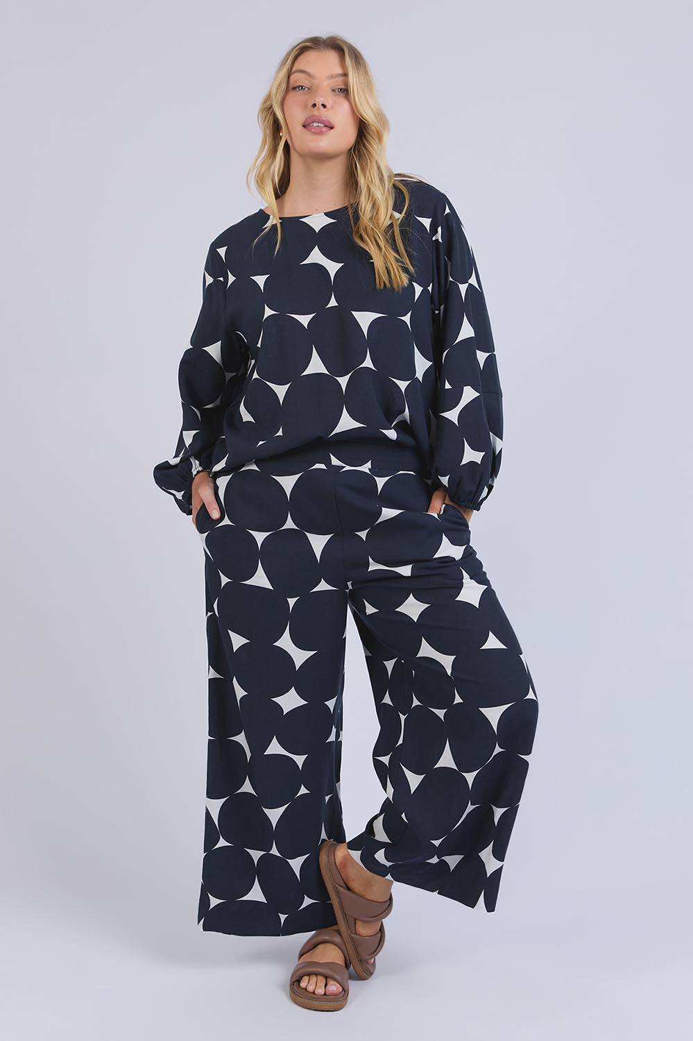 A model wearing the Demi Spot Lyocell Linen Pant in colour Spotprint (Blue), from the front, showing the whole outfit
