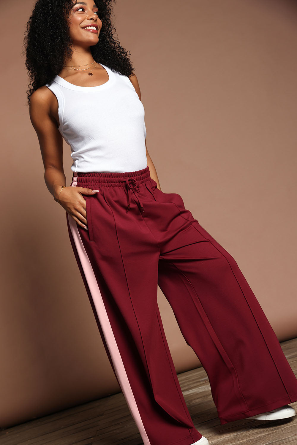 Model Ziara wearing size 10 of the Carmen Wide Leg Pant in colour Merlot (Red), from the front, showing the whole outfit