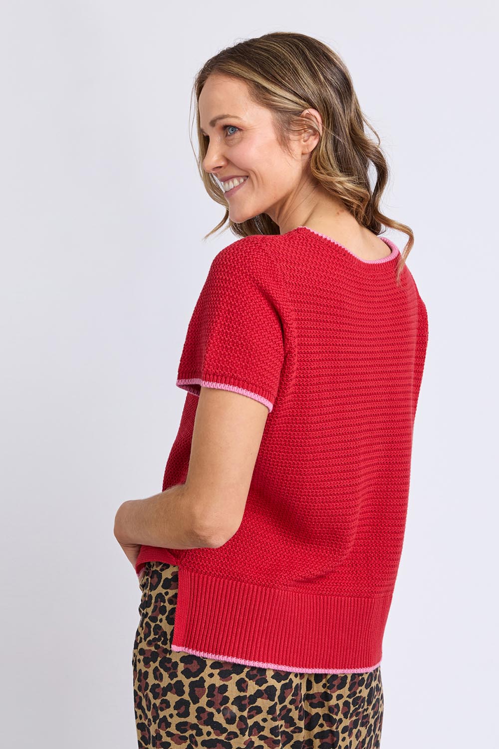A model wearing the Camellia Short Sleeve Cotton Knit in colour Cranberry (Red), from the back