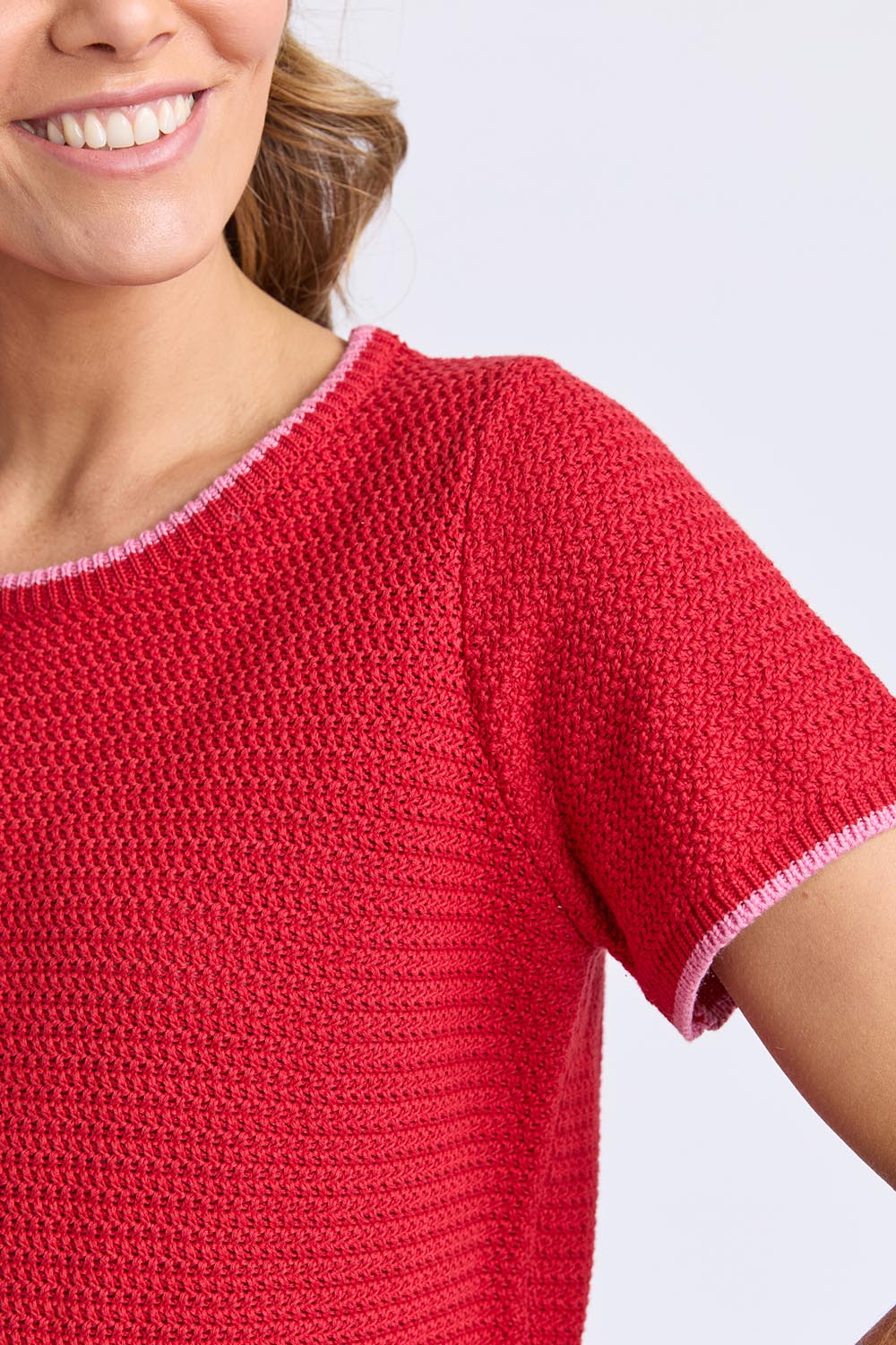 A model wearing the Camellia Short Sleeve Cotton Knit in colour Cranberry (Red), from the front, cropped image