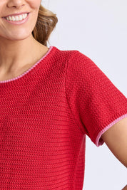 A model wearing the Camellia Short Sleeve Cotton Knit in colour Cranberry (Red), from the front, cropped image