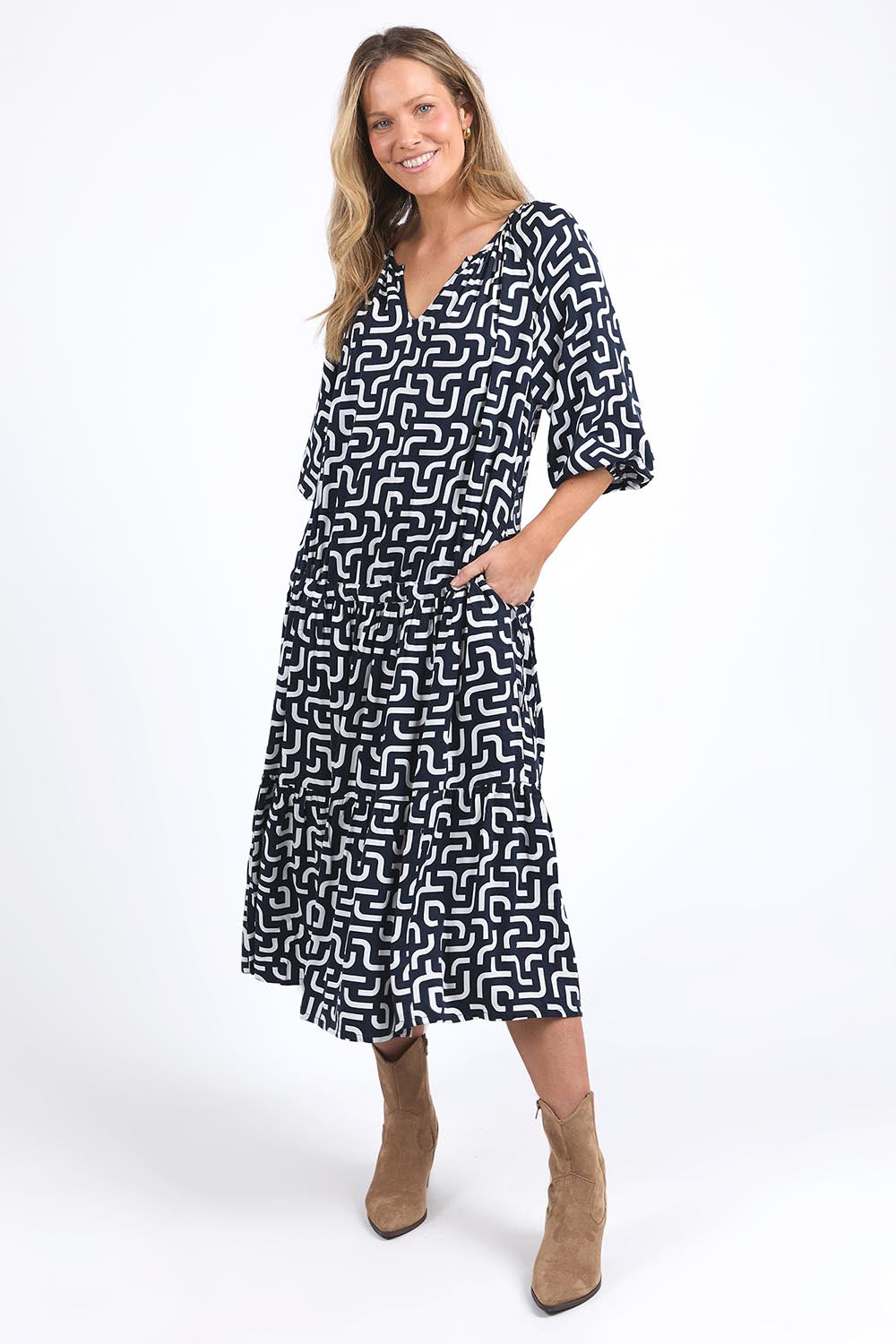 A model wearing the Gemma Geo Dress in colour Navygeo (Blue), from the front, showing the whole outfit