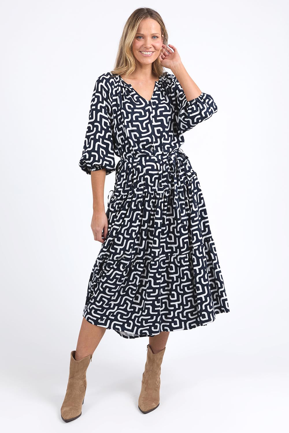 A model wearing the Gemma Geo Dress in colour Navygeo (Blue), from the front, showing the whole outfit
