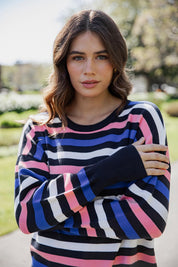 A model wearing the Logan Stripe Knit in colour Navy (Blue), from the front, cropped image