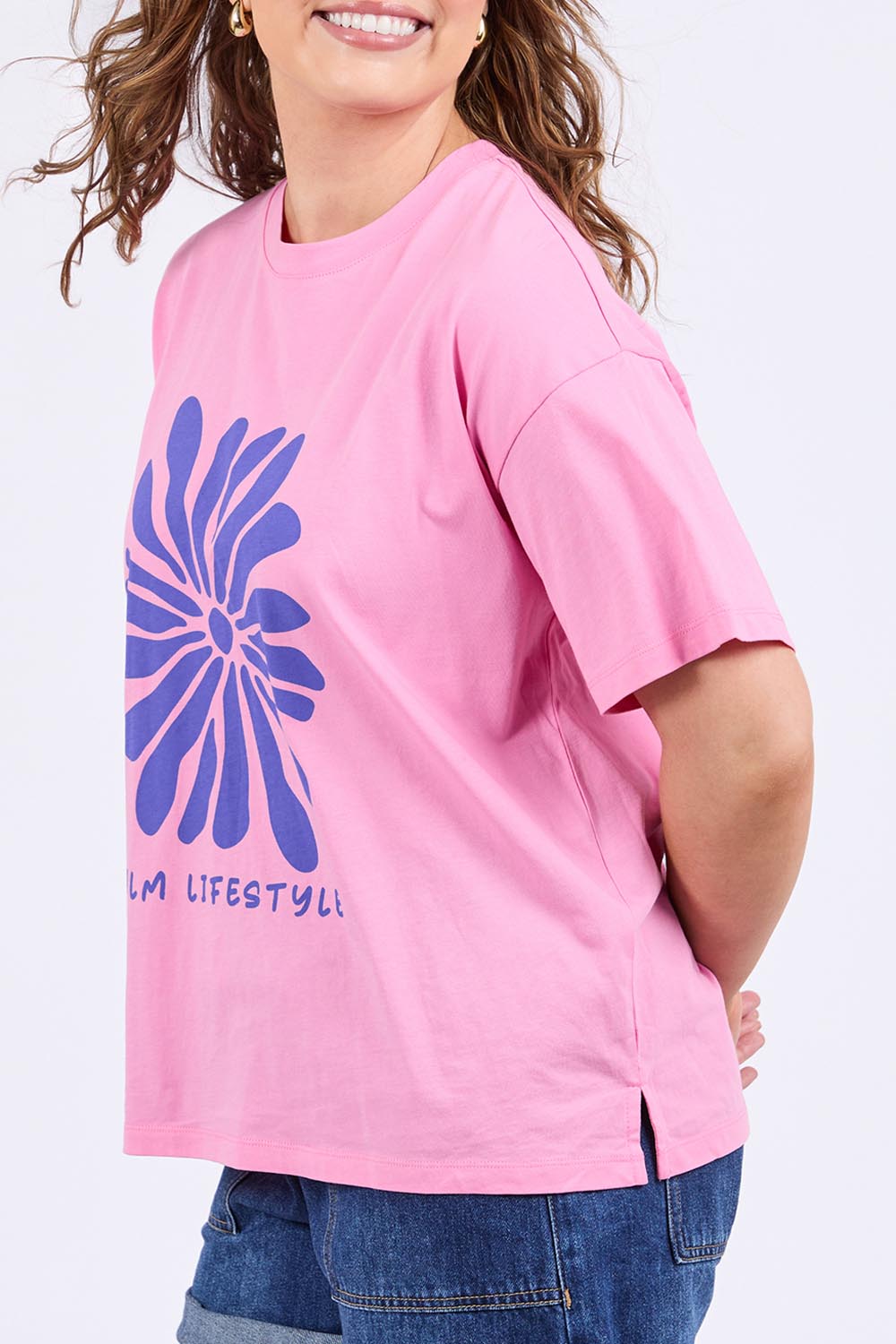 A model wearing the Camelia Cotton Tee in colour Chateauros (Pink), from the front, cropped image