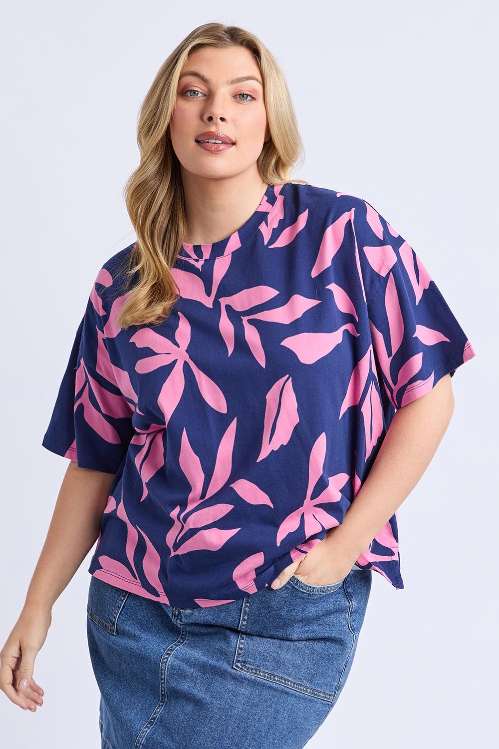 A model wearing the Mimosa Cotton Tee in colour Bluedepths, from the front, cropped image