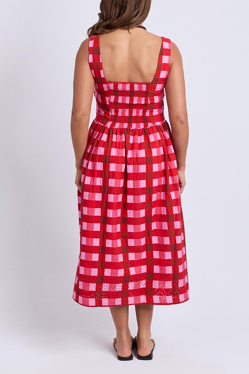 A model wearing the Edin Cotton Dress in colour Poppycheck, from the back