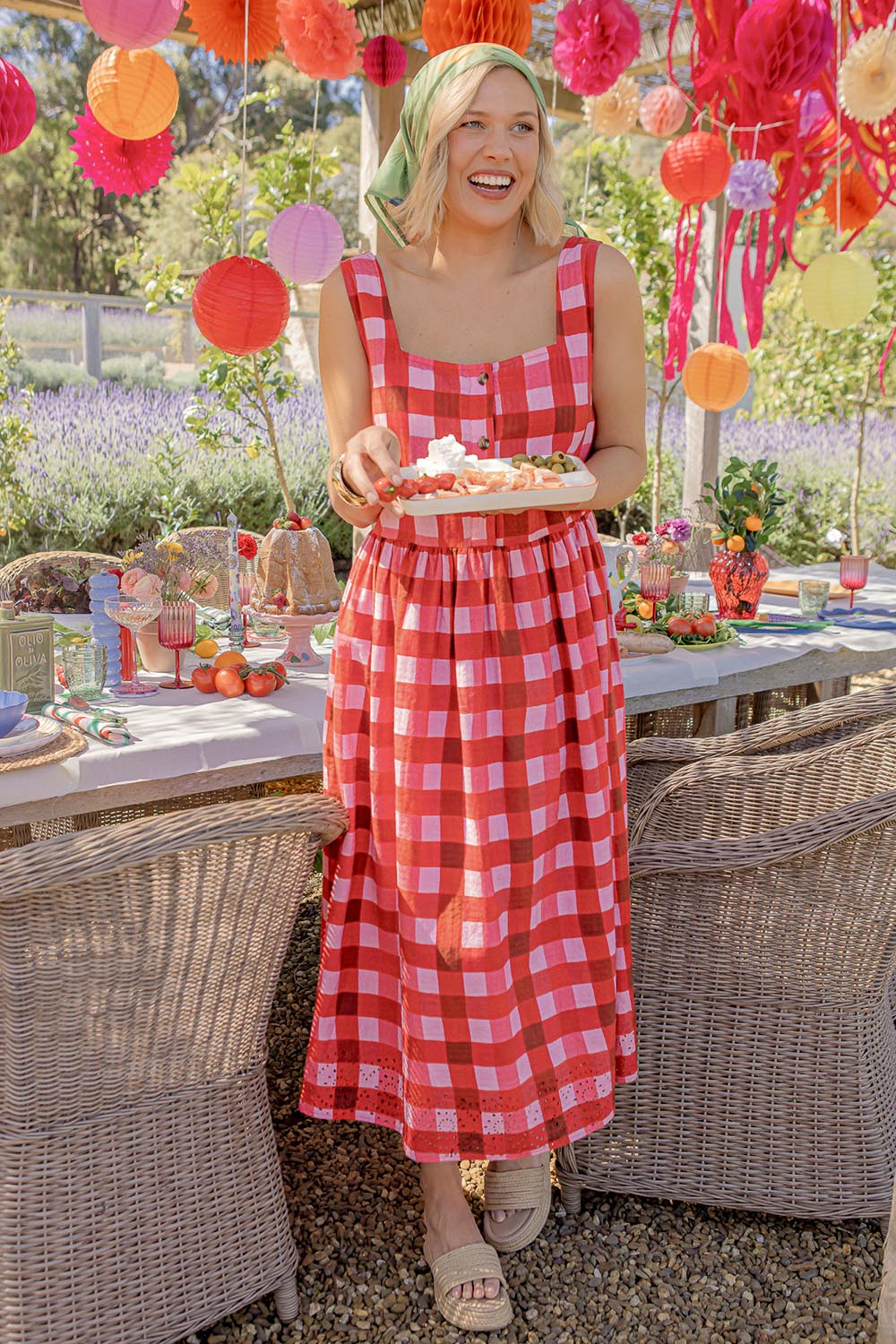 A model wearing the Edin Cotton Dress in colour Poppycheck, from the front, showing the whole outfit