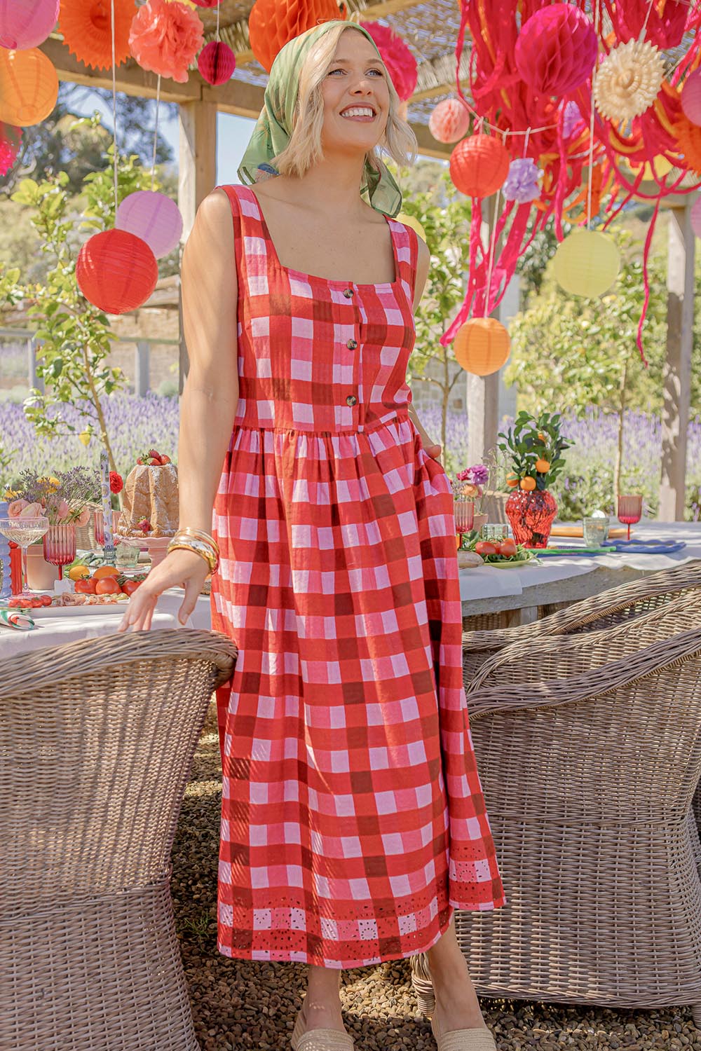 A model wearing the Edin Cotton Dress in colour Poppycheck, from the front, showing the whole outfit
