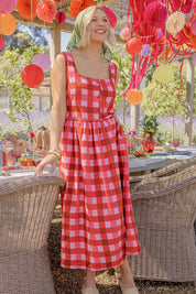 A model wearing the Edin Cotton Dress in colour Poppycheck, from the front, showing the whole outfit