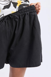 A model wearing the Lucinda Lyocell Cotton Short in colour Black (Black), from the front, cropped image