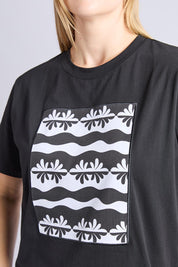 A model wearing the Casa Cotton Tee in colour Black (Black), from the front, cropped image