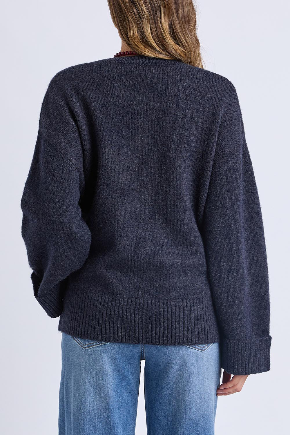 A model wearing the Intersia Heart Knit in colour Navy (Blue), from the back