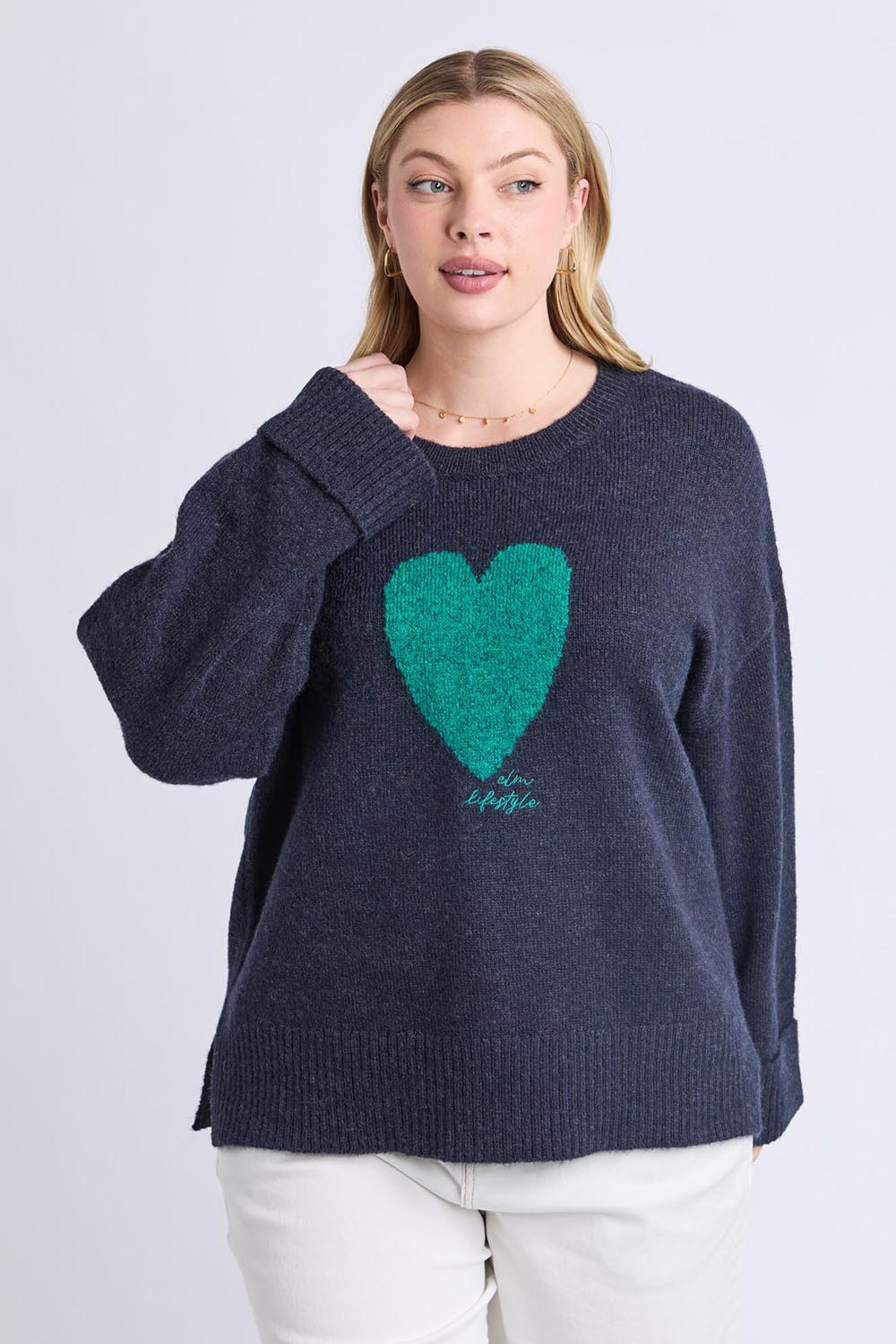 A model wearing the Intersia Heart Knit in colour Navy (Blue), from the front, cropped image