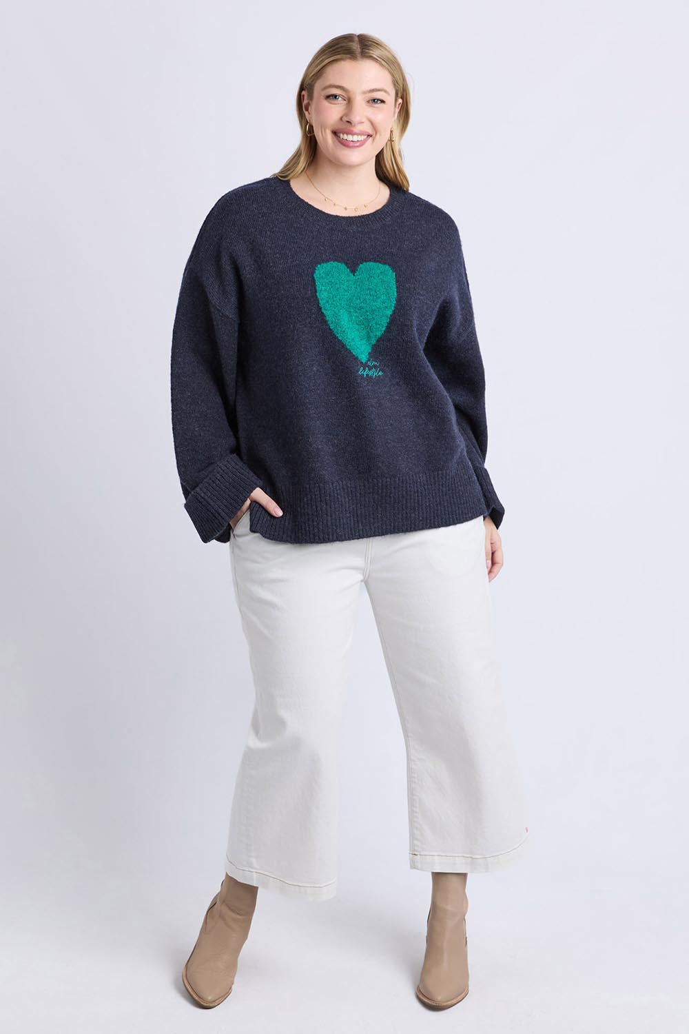 A model wearing the Intersia Heart Knit in colour Navy (Blue), from the front, showing the whole outfit