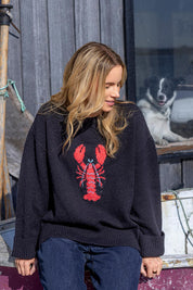 A model wearing the Lobster Intersaid Knit in colour Navy (Blue), from the front, showing the whole outfit