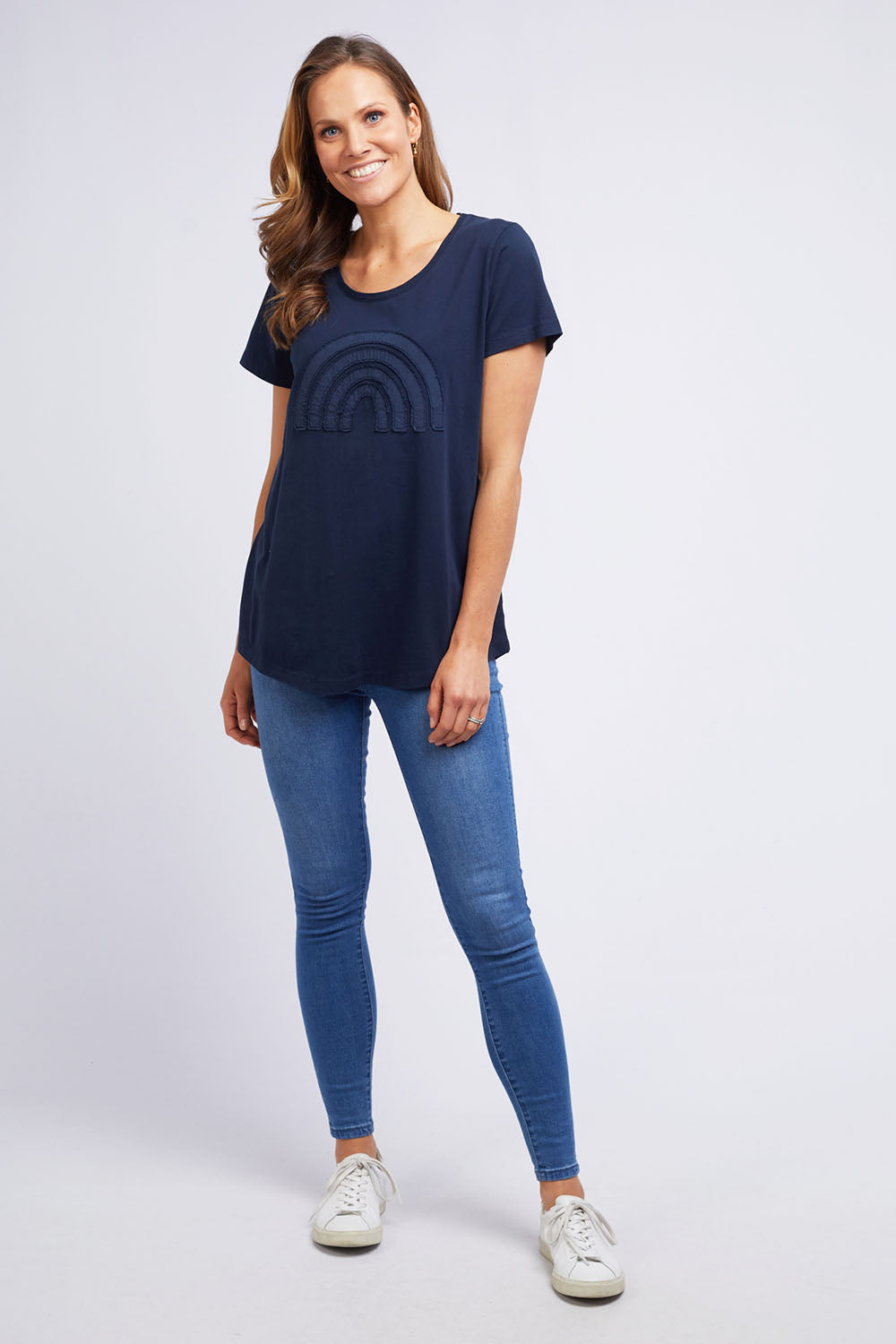 A model wearing the Crescent SS Tee in colour Navy (Green), from the front, showing the whole outfit