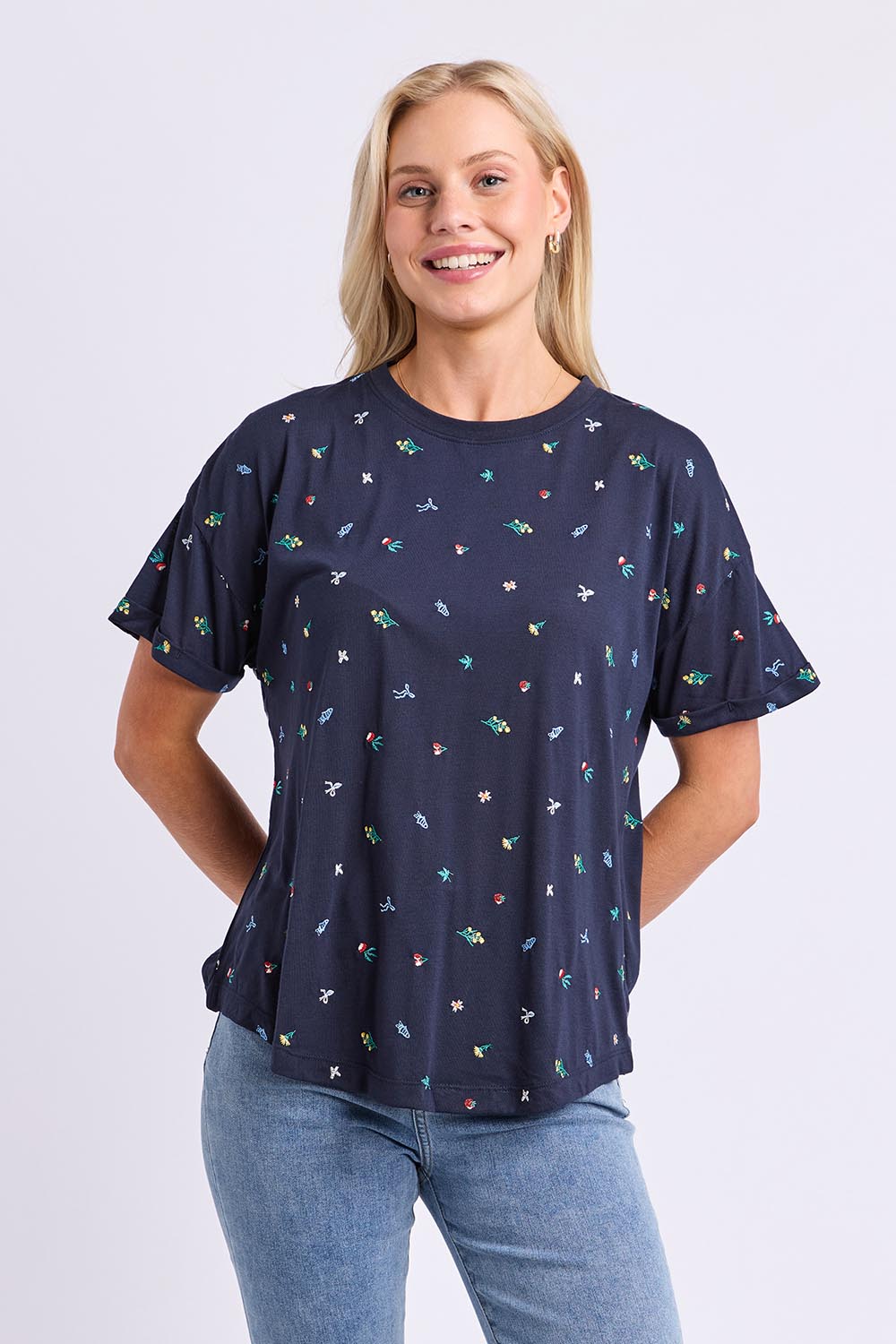 Model Genericm wearing size sample of the Festive Market Tee – Navy in colour Navy, in a cropped view