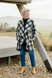 Model Elise wearing size S of the Cindy Check Coat in colour Charcoal (Grey), from the front, showing the whole outfit
