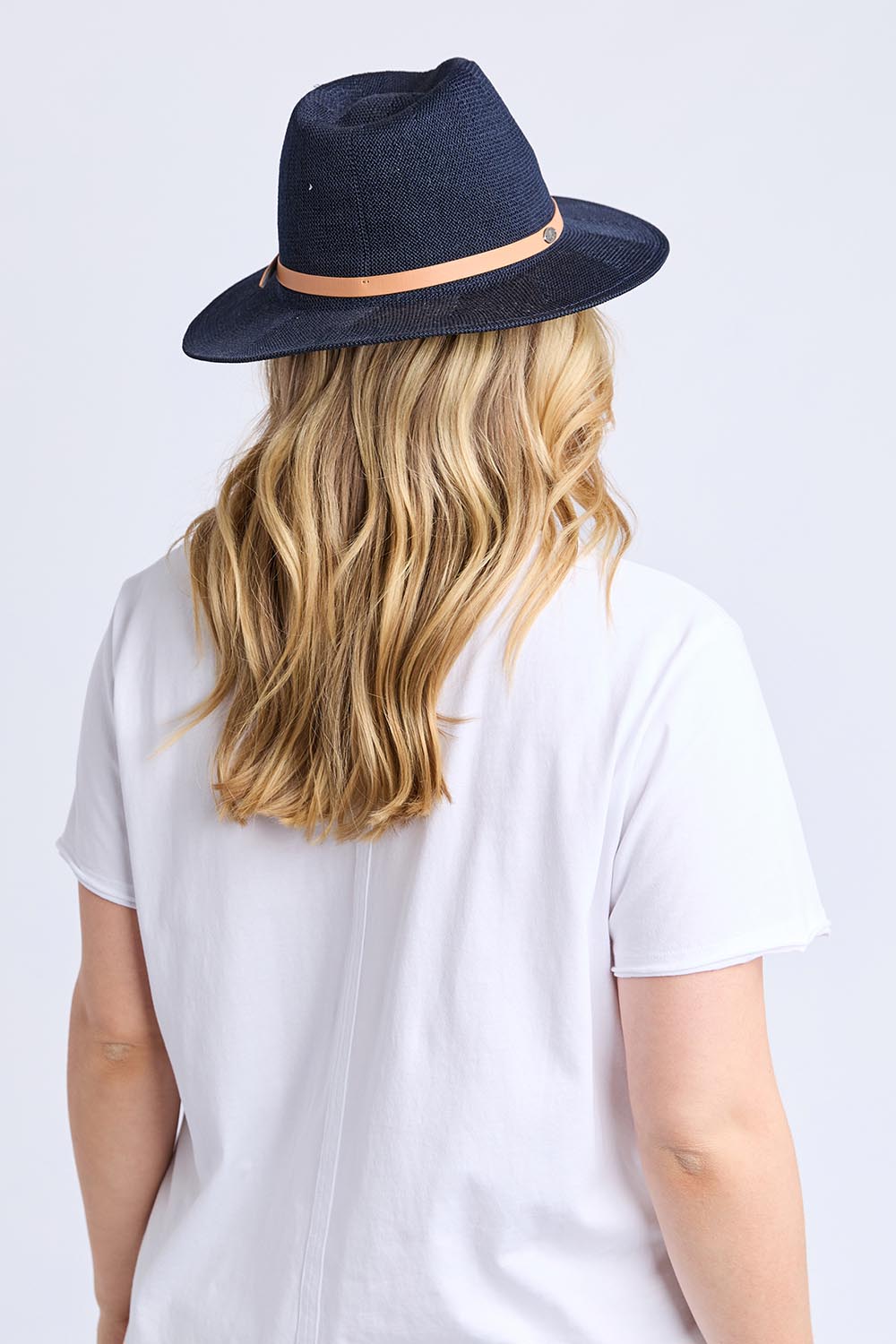 A model wearing the Palm Hat in colour Navy (Blue), from the back