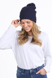 A model wearing the Berry Beanie in colour Navy (Blue), from the front, cropped image