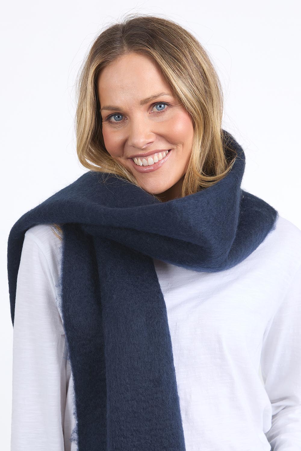 A model wearing the Cosy Scarf in colour Navy (Blue), from the front, cropped image