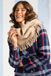 A model wearing the Fringed Triangle Scarf in colour Oatmeal, from the front, showing the whole outfit