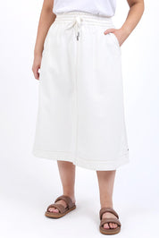 A model wearing the Fundamental Greta Denim Skirt in colour Vintgwhite (White), from the front, cropped image