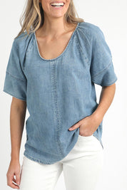A model wearing the Brea Top in colour Bluewash (Blue), from the front, cropped image