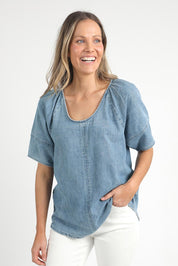 A model wearing the Brea Top in colour Bluewash (Blue), from the front, cropped image