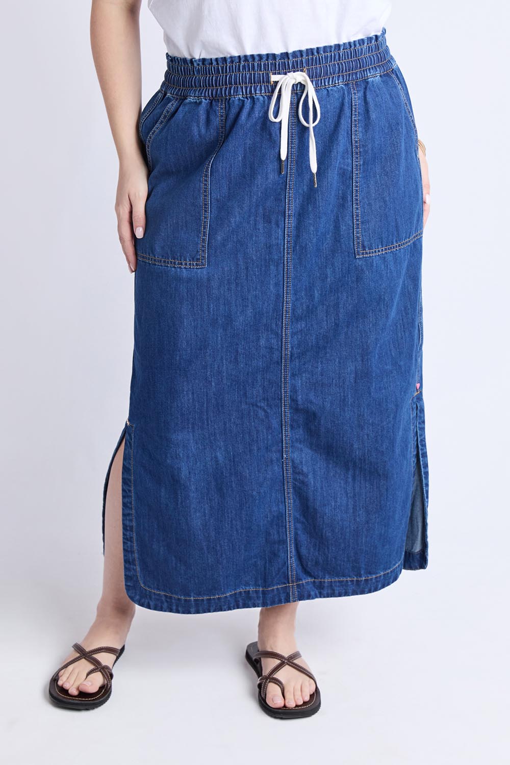 A model wearing the Clover Midi Denim Skirt in colour Midblue (Blue), from the front, cropped image