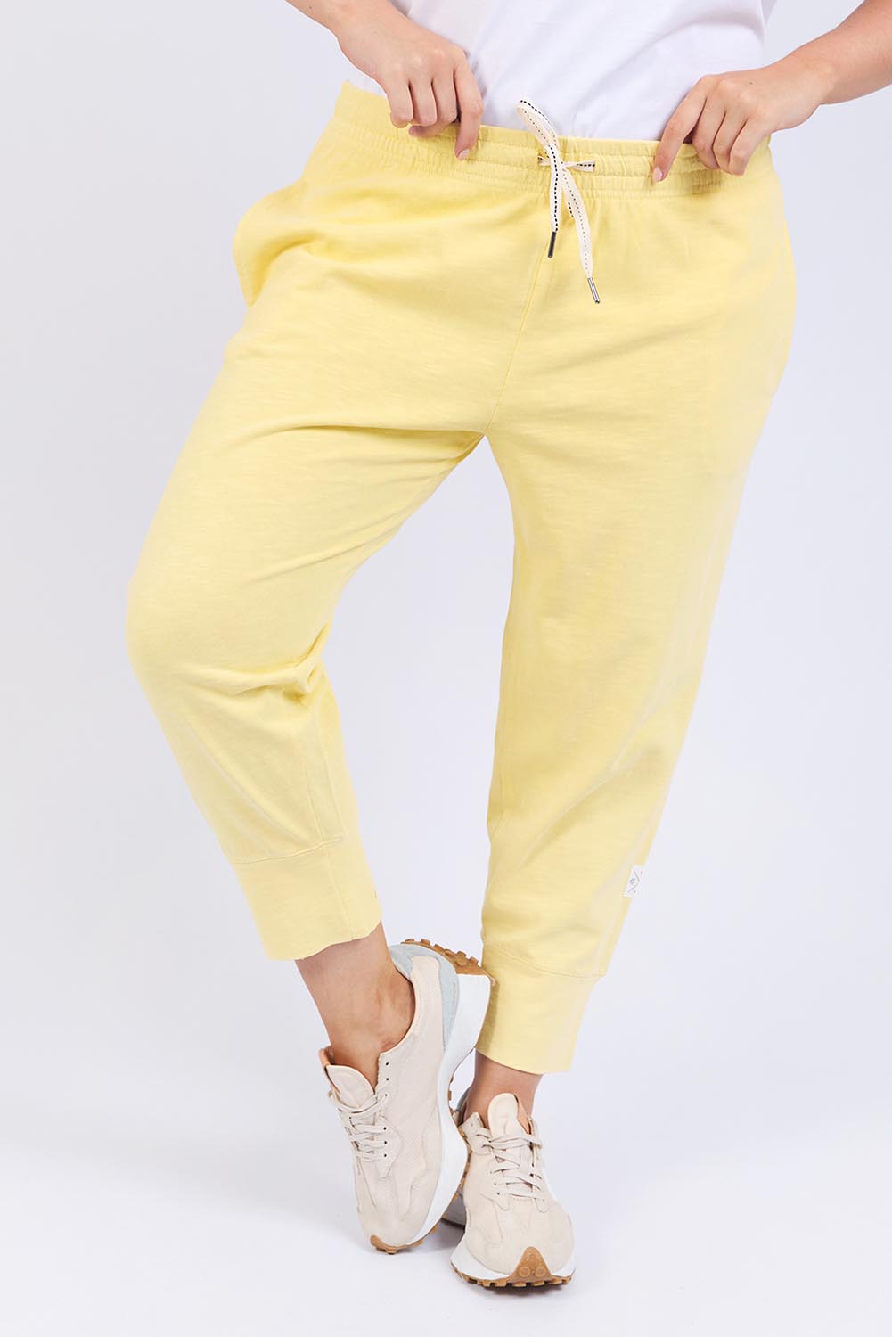 A model wearing the Fundamental Brunch Cotton Pant in colour Banana, from the front, cropped image