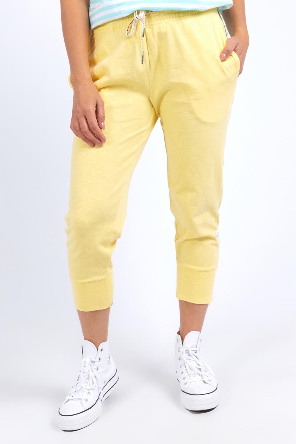 A model wearing the Fundamental Brunch Cotton Pant in colour Banana, from the front, cropped image