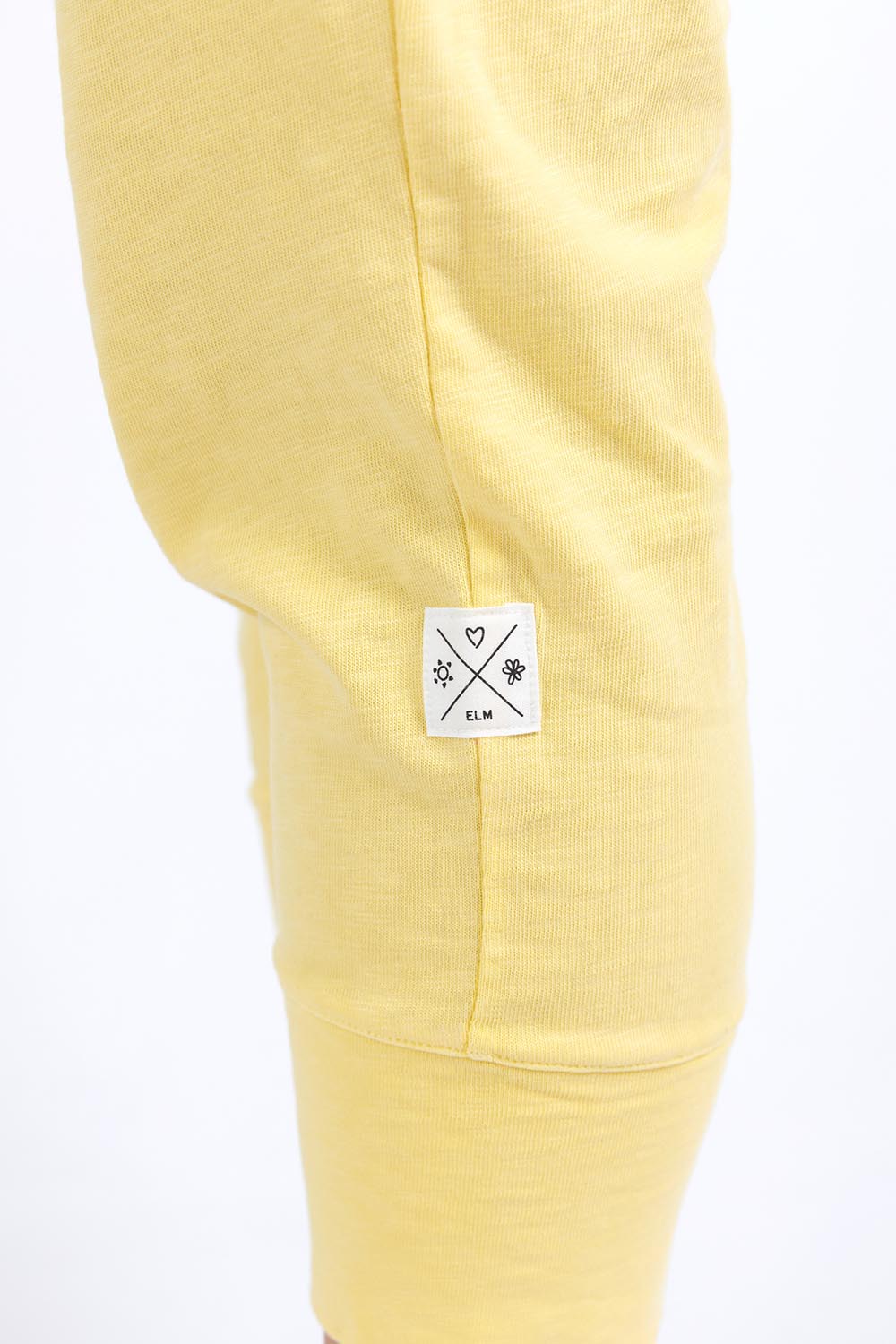 A model wearing the Fundamental Brunch Cotton Pant in colour Banana, from the front, cropped image