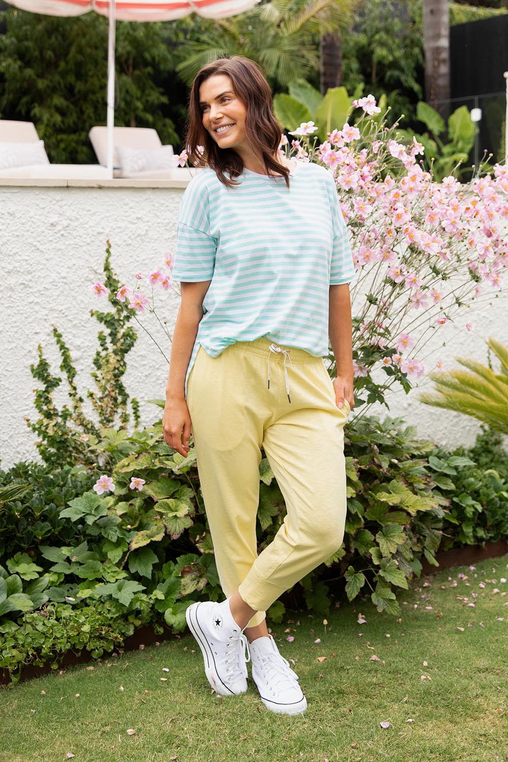 A model wearing the Fundamental Brunch Cotton Pant in colour Banana, from the front, showing the whole outfit