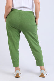 A model wearing the Fundamental Brunch Cotton Pant in colour Cedargreen (Green), from the back