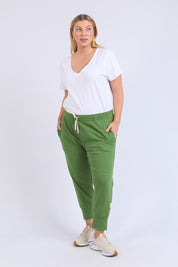 A model wearing the Fundamental Brunch Cotton Pant in colour Cedargreen (Green), from the front, showing the whole outfit