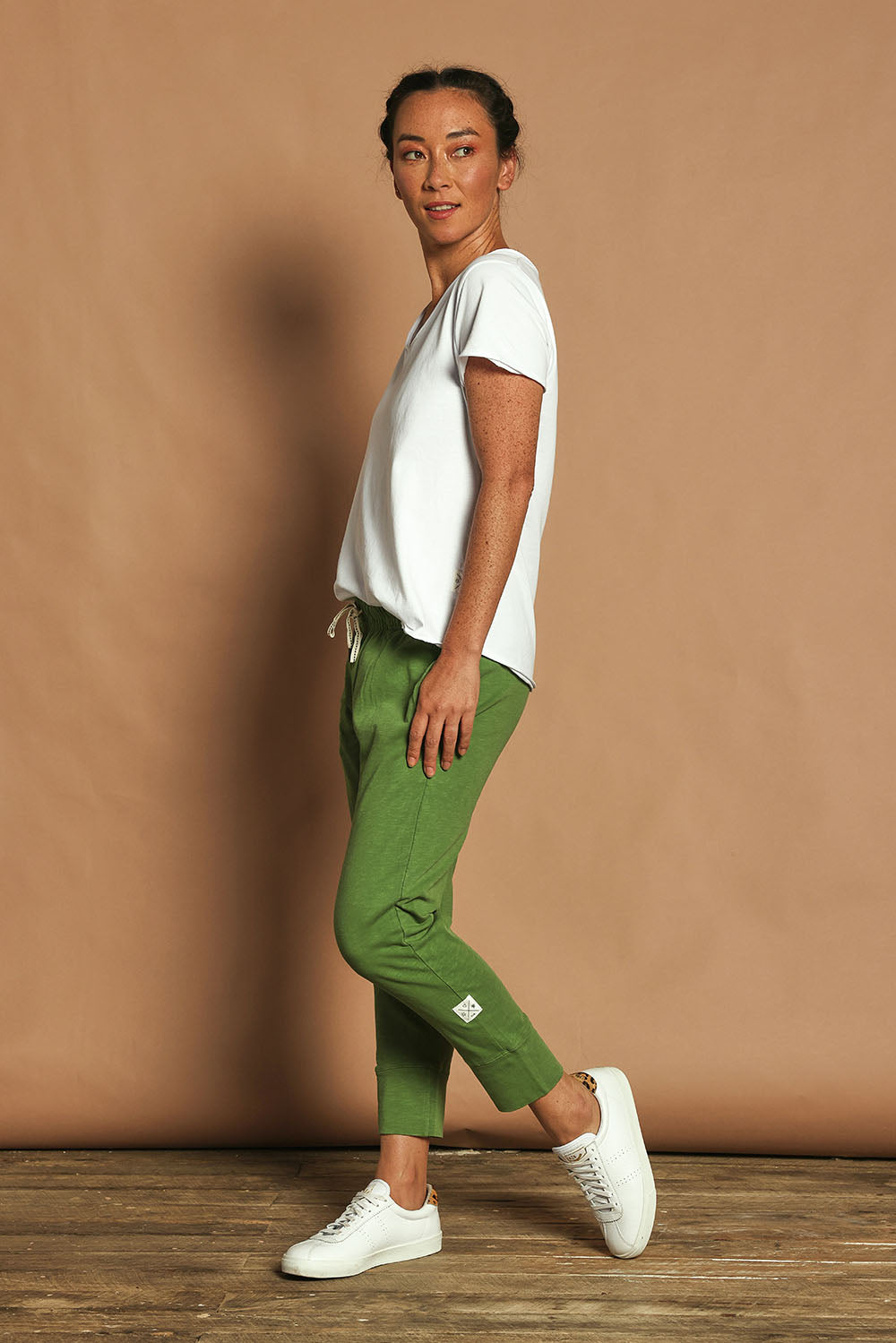 Model Katie wearing size 10 of the Fundamental Brunch Cotton Pant in colour Cedargreen (Green), from the front, showing the whole outfit