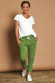 Model Katie wearing size 10 of the Fundamental Brunch Cotton Pant in colour Cedargreen (Green), from the front, showing the whole outfit