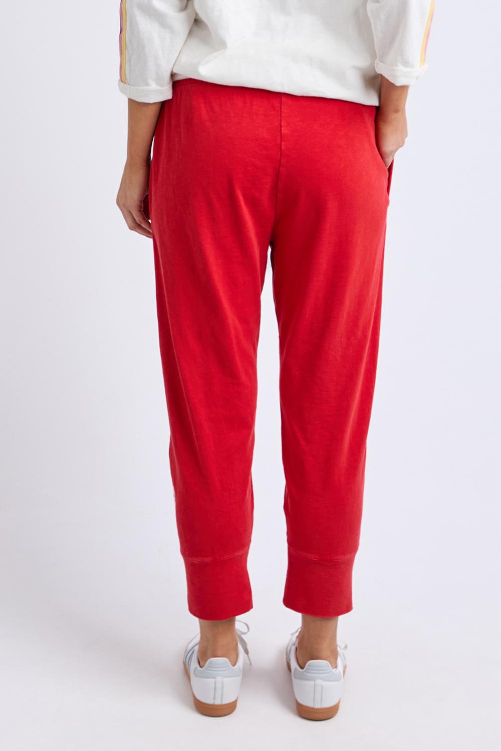 A model wearing the Fundamental Brunch Cotton Pant in colour Cranberry (Red), from the back
